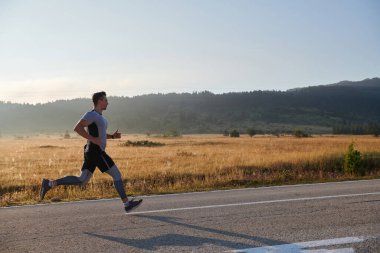 Atletik bir adam koşarken kararlılığını sergiler, sağlıklı bir yaşam tarzına ve yaklaşan maraton yarışmasına hazırlanmaya bağlıdır.