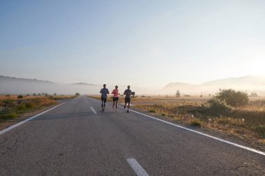 Bir grup arkadaş, sporcu ve koşucu sabahın erken saatlerinde güneşin doğuşuyla enerji dolu ve doğanın sakin güzelliğiyle çevrelenmiş bir şekilde puslu şafakta koşarken kucaklaşıyorlar.. 