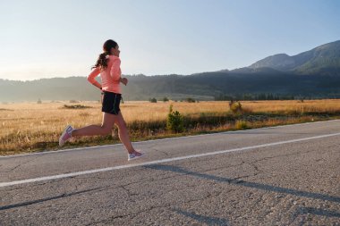 Kararlı ve motive olmuş bir sporcu gün doğumuna güvenle koşuyor, sabah koşusunda kararlılığını ve gücünü özetliyor.. 