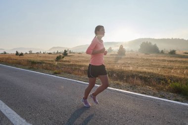 Kararlı ve motive olmuş bir sporcu gün doğumuna güvenle koşuyor, sabah koşusunda kararlılığını ve gücünü özetliyor.. 