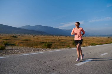 Kararlı ve motive olmuş bir sporcu gün doğumuna güvenle koşuyor, sabah koşusunda kararlılığını ve gücünü özetliyor.. 