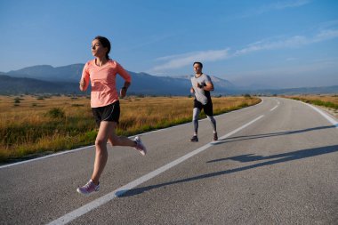Bir çift güneş lekeli bir yolda koşar, vücutları güçlü ve sağlıklıdır, birbirlerine olan sevgileri ve her adımda aşikardır.. 