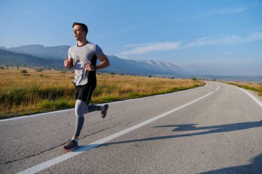 Atletik bir adam koşarken kararlılığını sergiler, sağlıklı bir yaşam tarzına ve yaklaşan maraton yarışmasına hazırlanmaya bağlıdır.