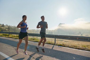 Bir çift güneş lekeli bir yolda koşar, vücutları güçlü ve sağlıklıdır, birbirlerine olan sevgileri ve her adımda aşikardır.. 