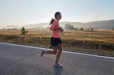 Kararlı ve motive olmuş bir sporcu gün doğumuna güvenle koşuyor, sabah koşusunda kararlılığını ve gücünü özetliyor.. 