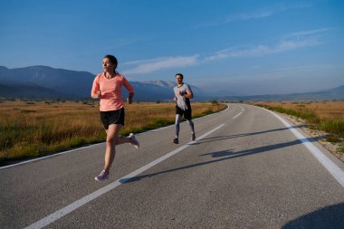 Bir çift güneş lekeli bir yolda koşar, vücutları güçlü ve sağlıklıdır, birbirlerine olan sevgileri ve her adımda aşikardır.. 