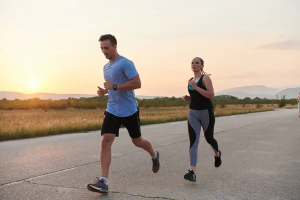 一对充满活力的夫妇在户外奔跑 体现了运动和浪漫的本质 他们自信的步伐反映了对健身的共同承诺和对未来马拉松赛的准备 — 图库照片