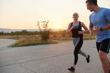 Açık havada koşan canlı bir çift atletizm ve romantizmin özünü somutlaştırıyor. Kendine güvenen adımları gelecekteki maratona ortak bir bağlılığı ve hazırlığı yansıtıyor.