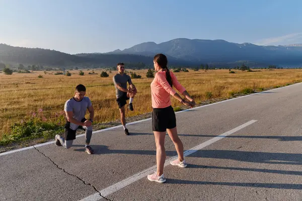 一群充满活力的 多样化的运动员正在进行伸展运动和热身运动 展示了他们的团结精神 并为充满活力的晨跑做好了准备 — 图库照片