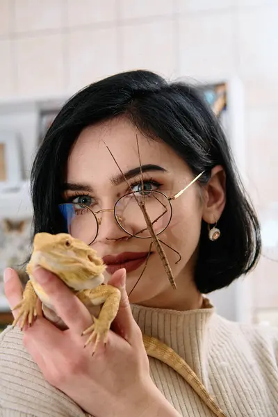 stock image A young woman poses with her two pets, a bearded dragon and a stick insect, in this heartwarming photo.