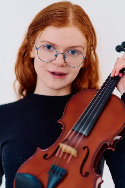 素晴らしい赤毛のミュージシャンは 彼女が彼女のヴァイオリンとポーズするように優雅さを誇り 優雅さと音楽の両方を体現しています — ストック写真