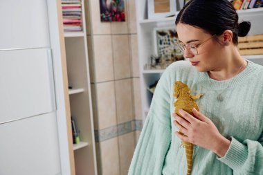 Neşeli bir anda güzel bir kadın, sevimli sakallı ejderha evcil hayvanlarıyla poz veriyor, sevgi ve arkadaşlık yayıyor..