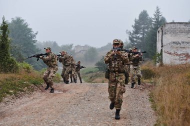 Disiplinli ve özel bir askeri birlik, kamuflajlı, stratejik devriye gezen ve yüksek bahisli bir ortamda kontrolü elinde tutan, hassasiyetlerini, birliklerini ve hazırlıklarını gösteren