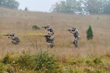 Disiplinli ve özel bir askeri birlik, kamuflajlı, stratejik devriye gezen ve yüksek bahisli bir ortamda kontrolü elinde tutan, hassasiyetlerini, birliklerini ve hazırlıklarını gösteren