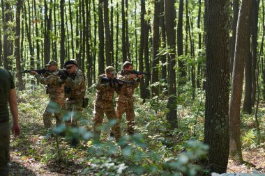 A specialized military antiterrorist unit conducts a covert operation in dense, hazardous woodland, demonstrating precision, discipline, and strategic readiness.  clipart