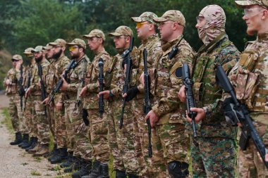Asker savaşçılar silahlarla birlikte duruyorlar. Amerikan ordusunun seçkin üyelerinin grup portresi, özel askeri şirket çalışanları, anti-terör ekibi.. 