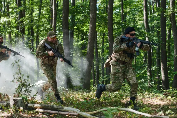 stock image A specialized military antiterrorist unit conducts a covert operation in dense, hazardous woodland, demonstrating precision, discipline, and strategic readiness. 