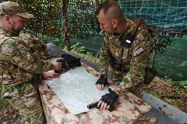 A highly trained military unit strategizes and organizes a tactical mission while studying a military map during a briefing session.
