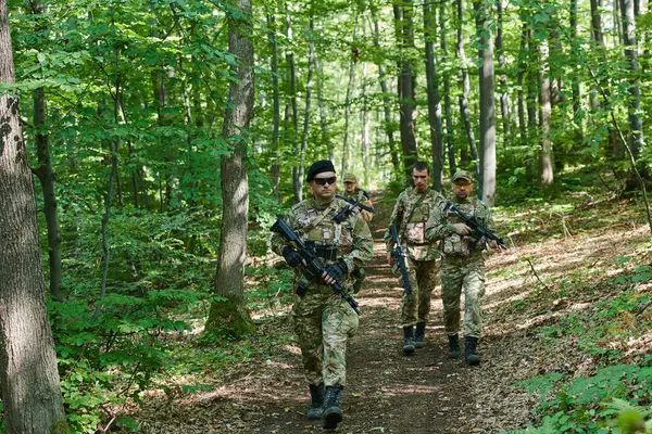 stock image A specialized military antiterrorist unit conducts a covert operation in dense, hazardous woodland, demonstrating precision, discipline, and strategic readiness. 