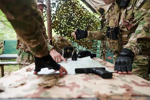 A highly trained military unit strategizes and organizes a tactical mission while studying a military map during a briefing session.