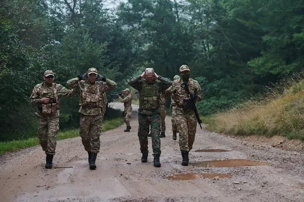 Группа Элитных Солдат Ведет Пленных Через Военный Лагерь Демонстрируя Напряженную — стоковое фото