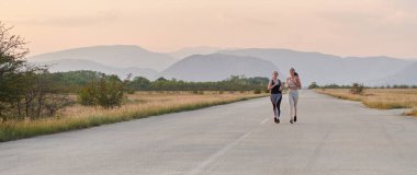 Güneşli bir günde, iki atletik arkadaş birlikte koşmaktan zevk alır, sağlıklı yaşam tarzlarını ve formda kalma rejimlerini sürdürürler..