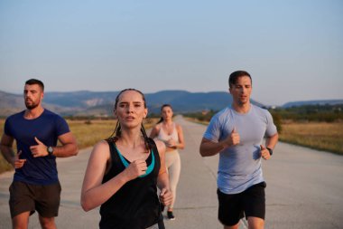 Bir grup arkadaş, güneşli bir günde dışarıda koşuşturarak sağlıklı bir yaşam tarzını sürdürüyor. Spor ve doğanın enerji verici etkilerinden keyif alıyorlar.. 