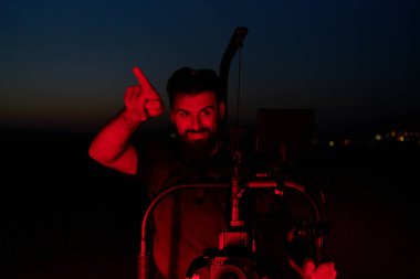 Yetenekli bir kameraman, gece antrenmanlarının enerjisini ve kararlılığını özetleyen canlı kırmızı ışıklarla aydınlatılan koşan sporcuların yoğunluğunu yakalar..