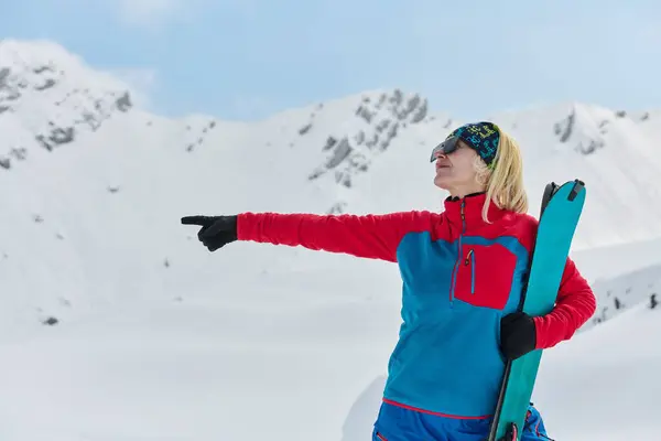 一位专业的滑雪者在爬上阿尔卑斯山的雪峰后很高兴 — 图库照片