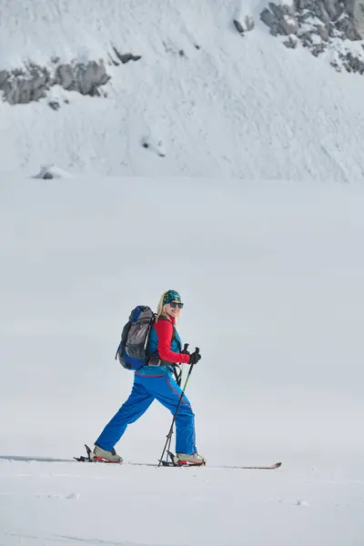 一个有决心的滑雪者爬上阿尔卑斯山雪峰 带着远征的装备准备进行史诗般的降落 — 图库照片