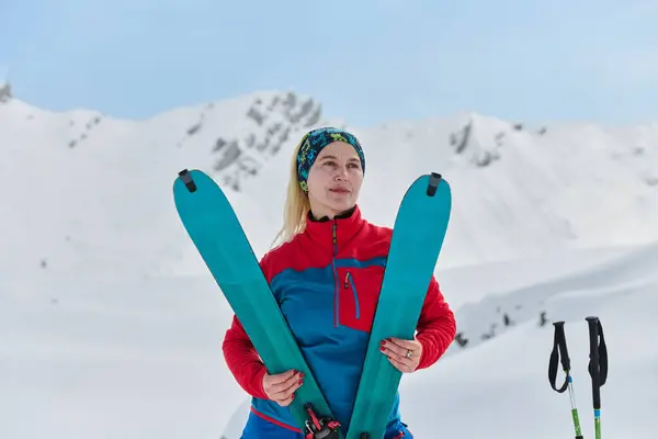 一位得意洋洋的女滑雪者在征服了具有挑战性的攀登后 自信地爬上了白雪覆盖的山峰 — 图库照片