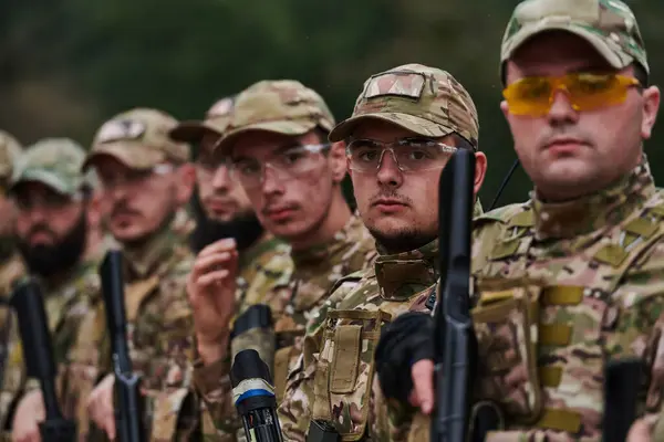 Soldier fighters standing together with guns. Group portrait of US army elite members, private military company servicemen, anti terrorist squad.