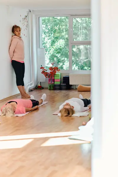 Formateur Qualifié Supervise Groupe Femmes Âgées Pratiquant Divers Exercices Yoga Image En Vente