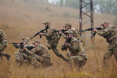 Disiplinli ve özel bir askeri birlik, kamuflajlı, stratejik devriye gezen ve yüksek bahisli bir ortamda kontrolü elinde tutan, hassasiyetlerini, birliklerini ve hazırlıklarını gösteren