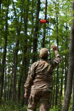 Elit askeri birim, son teknolojiyle donatılmış insansız hava aracı dahil, stratejik olarak ormanlık alanda geziniyor ve araştırıyor, hassasiyetlerini, iş birliklerini ve uzmanlıklarını gösteriyor.