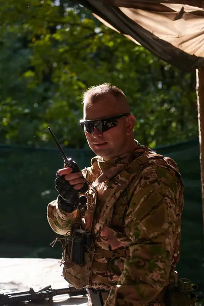 一名少校在战术行动中使用摩托罗拉无线电与他的士兵进行无缝交流 表现出专业精神和战略协调 — 图库照片