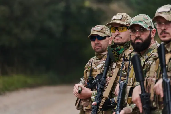 兵士の戦闘機は銃と一緒に立っている 米軍エリートメンバーのグループ肖像 民間軍事会社の軍人 反テロ部隊 ロイヤリティフリーのストック写真