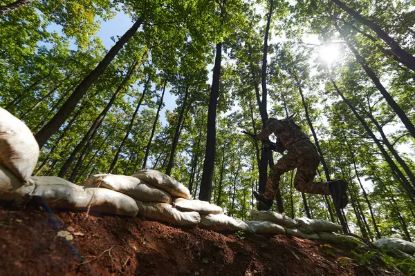 一名精锐的士兵在险峻的森林中巧妙地清除了军事障碍 在专门训练中展示了战术技巧和灵活性 — 图库照片