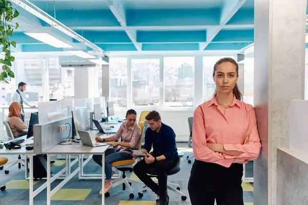 創造的なオープンスペースのコワーキングスタートアップオフィスでの若い笑顔のビジネス女性の肖像 コピースペース付きオフィスに立つ成功した実業家 バックグラウンドで働く労働者 — ストック写真