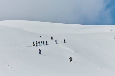 Bir grup profesyonel kayak dağcısı son model ekipmanlarla tehlikeli bir kar zirvesine tırmandılar.. 