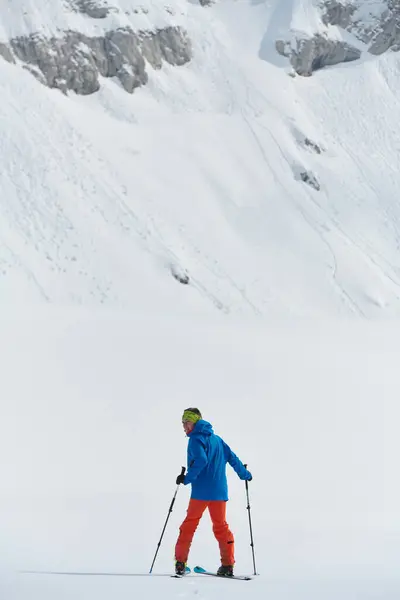 一个孤独的滑雪者冒着危险爬上高山山顶 — 图库照片