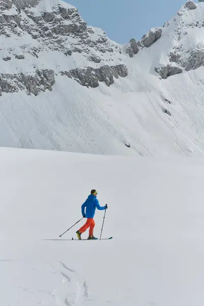 一个孤独的滑雪者冒着危险爬上高山山顶 — 图库照片