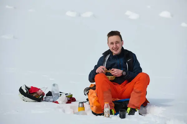 スキーヤーは平和の瞬間を味わい 息をのむアルパインパノラマで取るために雪に覆われた尾根の上に一時停止します — ストック写真