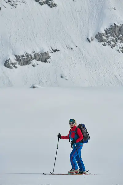 女性のスキーヤーは プロのギアとスキーを装備した山の雪の頂上に立っています 爽快な降下のためにプッシュ — ストック写真