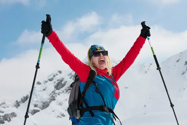 Eine Professionelle Skifahrerin Jubelt Nach Der Erfolgreichen Besteigung Der Schneebedeckten lizenzfreie Stockfotos