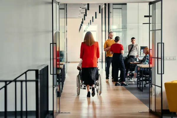 Affärskvinna Hjälper Sin Kollega Rullstol När Navigerar Eleganta Korridorerna Ett Stockbild