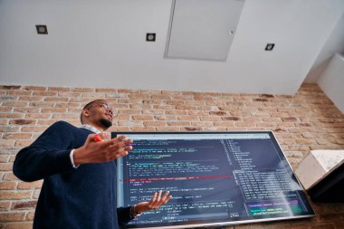 Afrikalı Amerikalı iş adamı iş stratejisini meslektaşlarına sunuyor, işbirliğini ve ileriyi düşünmeyi teşvik ediyor..