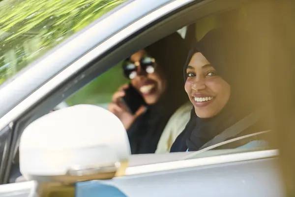 Muslimske Kvinder Iført Hijab Konversere Smartphone Mens Rejser Sammen Bil Royaltyfrie stock-billeder