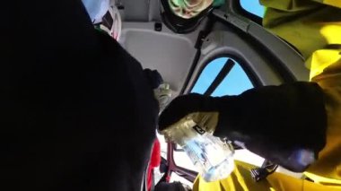 Helikopter kayakçıları dağın yamacında uçarak kar bulutu oluşturdular. Güzel bir kış güneşli bir günde bir grup arkadaş taze toz karda serbest kayak yapmak için helikoptere biniyor.