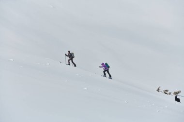 İki profesyonel kayakçı, sarsılmaz takım çalışması ve kararlılığıyla Alpler 'in karlı zirvelerine tırmanarak zirve arayışında birleştiler.. 